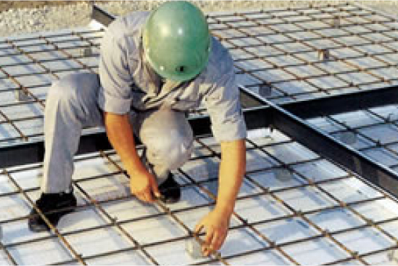 施工現場で床にドマライトを敷き詰める現場作業員