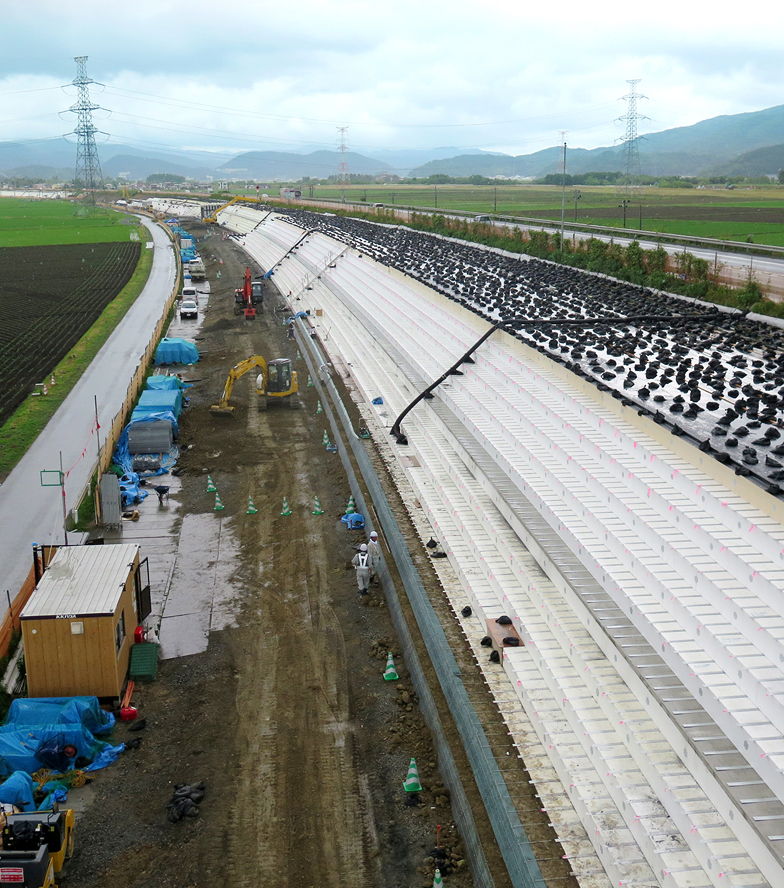 軟弱地盤や地すべり地での盛土として土木資材を使用している様子