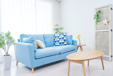 青いソファーと木星の丸いローテーブルがあるリビング